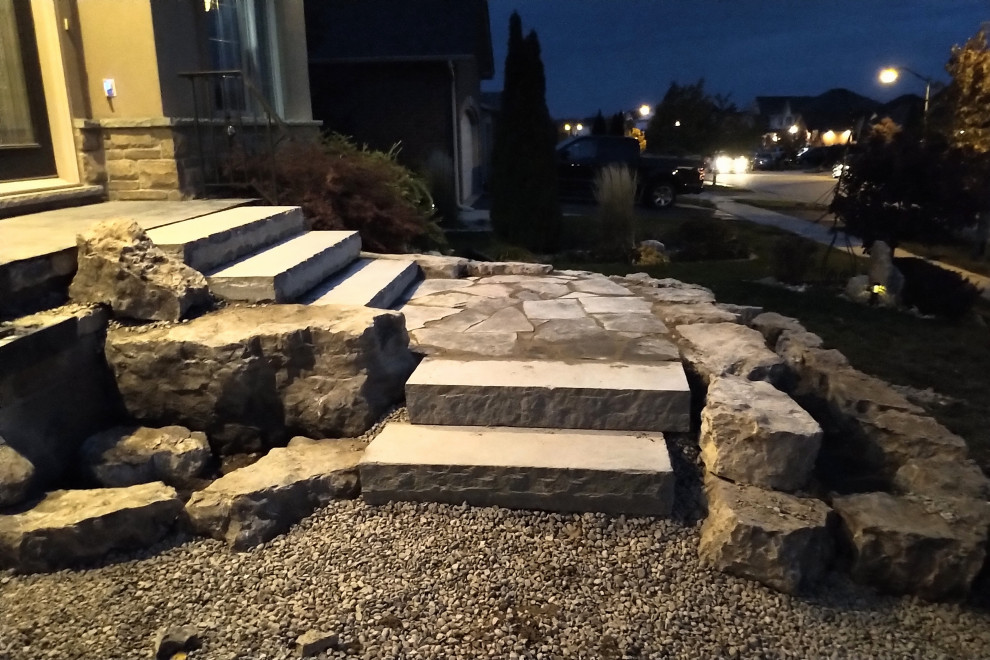 Inspiration for a mid-sized rustic rock and partial sun front yard stone driveway in Toronto.