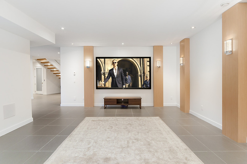 Expansive contemporary open concept home theatre in Vancouver with white walls, porcelain floors, a built-in media wall and grey floor.