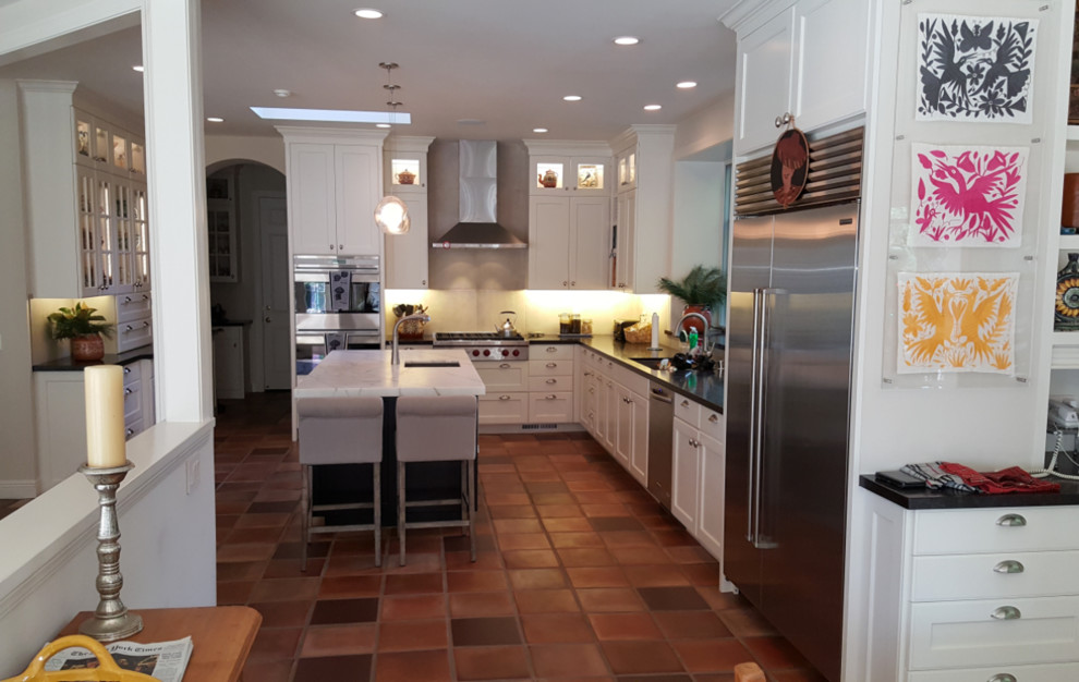 Inspiration for a large transitional u-shaped terra-cotta tile kitchen remodel in San Francisco with an undermount sink, shaker cabinets, white cabinets, quartzite countertops, stainless steel appliances and an island