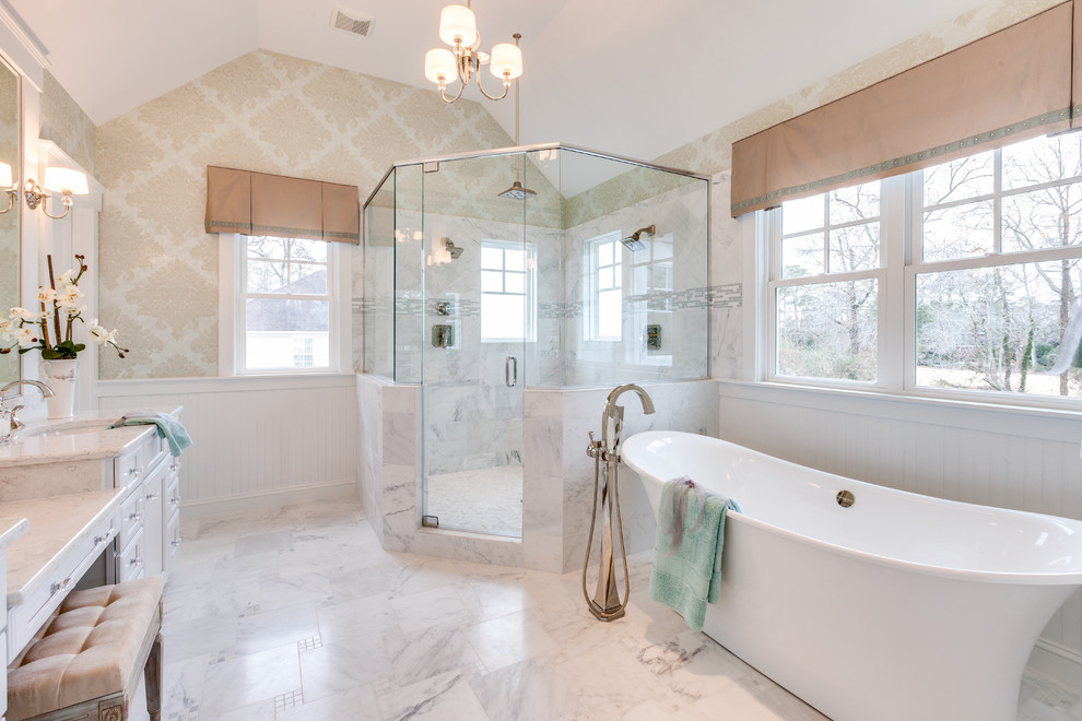 Design ideas for a large master bathroom in Other with an undermount sink, recessed-panel cabinets, white cabinets, marble benchtops, a freestanding tub, a corner shower, a two-piece toilet, white tile, stone tile, grey walls and marble floors.