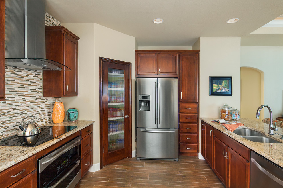 Mid-sized transitional galley porcelain tile kitchen pantry photo in Austin with an undermount sink, recessed-panel cabinets, medium tone wood cabinets, granite countertops, mosaic tile backsplash, stainless steel appliances, beige walls, a peninsula and multicolored backsplash