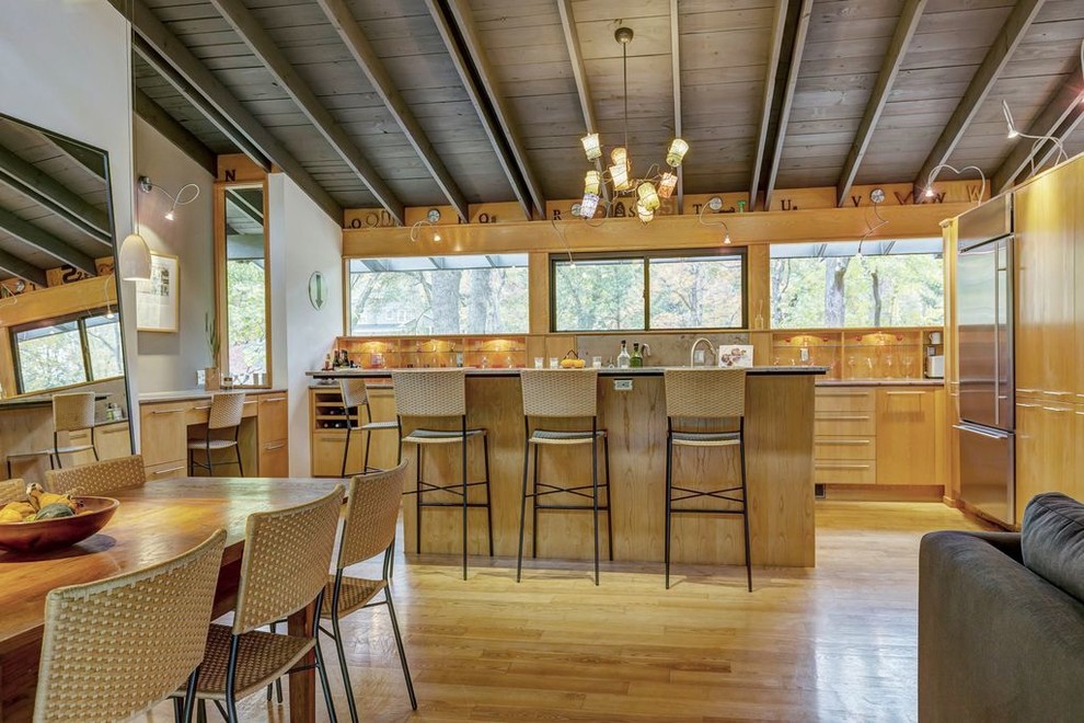 Small midcentury galley eat-in kitchen in St Louis with an undermount sink, flat-panel cabinets, light wood cabinets, limestone benchtops, beige splashback, limestone splashback, stainless steel appliances, light hardwood floors, with island and beige floor.