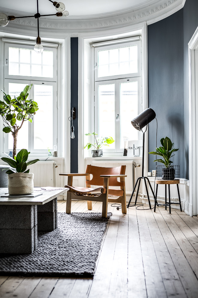 This is an example of a mid-sized scandinavian living room in Stockholm with light hardwood floors, no fireplace, beige floor and grey walls.