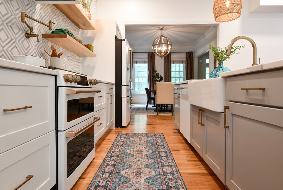 Inspiration for a small modern galley kitchen in DC Metro with a farmhouse sink, recessed-panel cabinets, quartz benchtops, white appliances and with island.