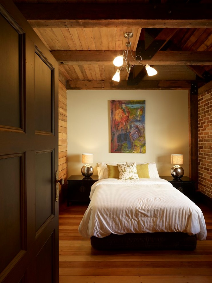 Inspiration for a mid-sized eclectic guest bedroom in Sydney with brown walls and medium hardwood floors.