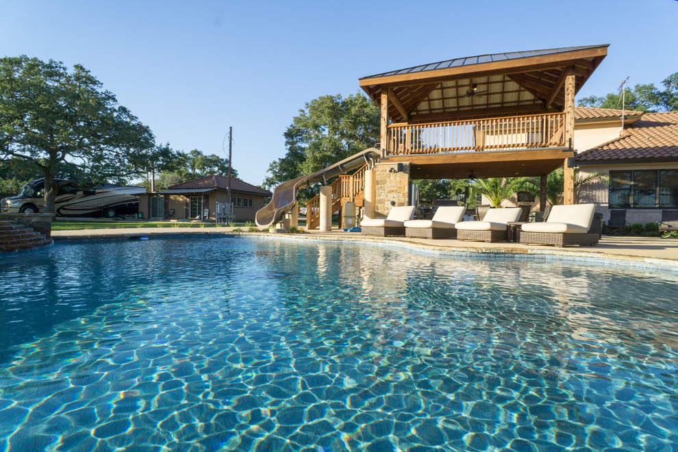 Inspiration for a large rustic backyard stone and custom-shaped pool fountain remodel in Austin