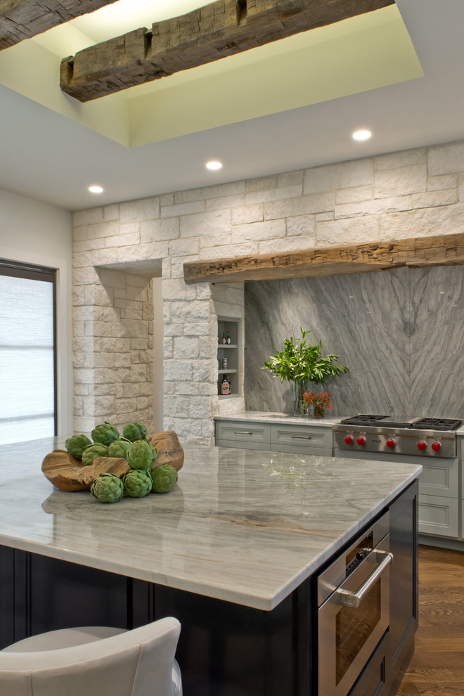 Example of a transitional l-shaped medium tone wood floor open concept kitchen design in Austin with an undermount sink, recessed-panel cabinets, green cabinets, quartzite countertops, green backsplash, stone slab backsplash, stainless steel appliances and an island