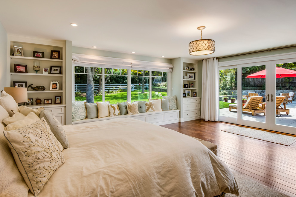This is an example of a large traditional master bedroom in Los Angeles with beige walls and medium hardwood floors.