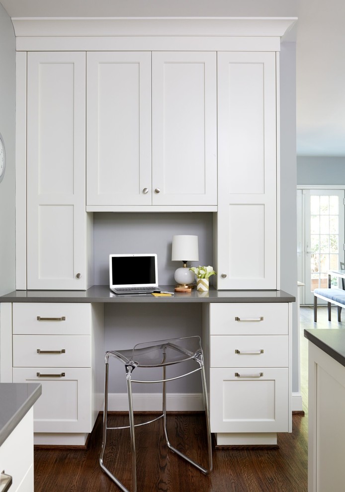 Mid-sized transitional u-shaped dark wood floor and brown floor enclosed kitchen photo in DC Metro with a farmhouse sink, shaker cabinets, white cabinets, solid surface countertops, white backsplash, subway tile backsplash, stainless steel appliances and an island