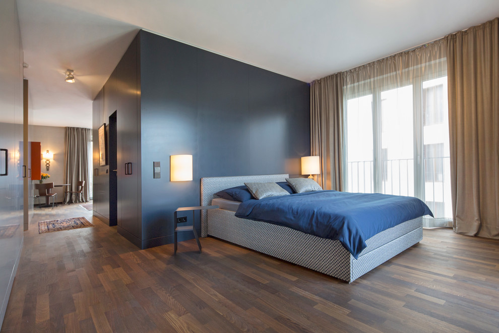 Großes Klassisches Hauptschlafzimmer mit blauer Wandfarbe und dunklem Holzboden in Berlin