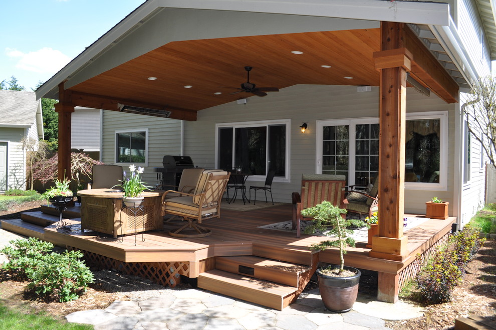 Photo of a mid-sized transitional backyard patio in Seattle with a fire feature, decking and a roof extension.