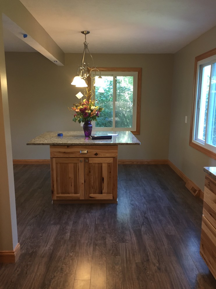 Example of a mid-sized mountain style u-shaped laminate floor and brown floor eat-in kitchen design in Omaha with an undermount sink, raised-panel cabinets, light wood cabinets, quartz countertops, beige backsplash, porcelain backsplash, stainless steel appliances, an island and gray countertops