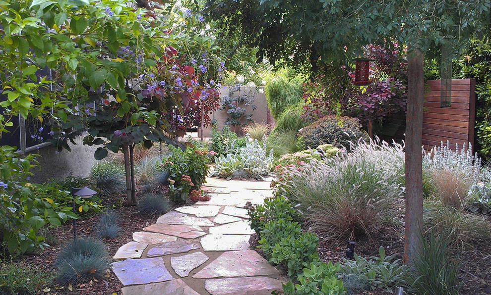 This is an example of a mid-sized eclectic side yard partial sun garden in Los Angeles with a garden path and natural stone pavers.