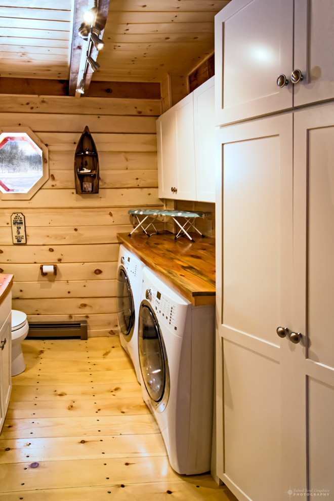 Photo of a small arts and crafts galley utility room in Burlington with shaker cabinets, beige cabinets, wood benchtops, a side-by-side washer and dryer, a drop-in sink, brown walls and light hardwood floors.