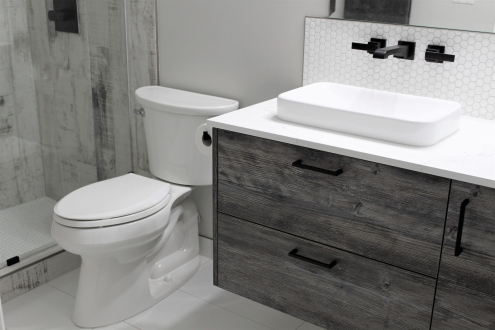 This is an example of a small country kids bathroom in Calgary with flat-panel cabinets, distressed cabinets, an alcove tub, a shower/bathtub combo, a one-piece toilet, white tile, mosaic tile, grey walls, porcelain floors, a vessel sink, engineered quartz benchtops, white floor, an open shower, white benchtops, a niche, a single vanity and a floating vanity.