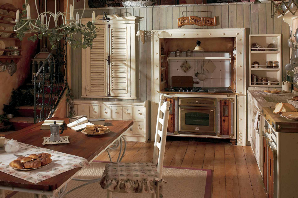 Bild på ett mellanstort lantligt vit vitt kök, med vita skåp, träbänkskiva, vitt stänkskydd, rostfria vitvaror, skiffergolv, en rustik diskho, luckor med lamellpanel och brunt golv