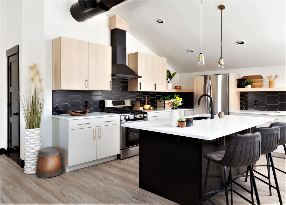 This is an example of a scandinavian l-shaped kitchen in Denver with an undermount sink, flat-panel cabinets, black splashback, stainless steel appliances, with island, beige floor and white benchtop.