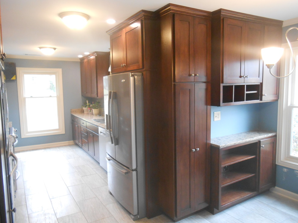 Example of a mid-sized transitional galley porcelain tile eat-in kitchen design with an undermount sink, shaker cabinets, dark wood cabinets, quartz countertops, beige backsplash, glass sheet backsplash, stainless steel appliances, blue walls and no island