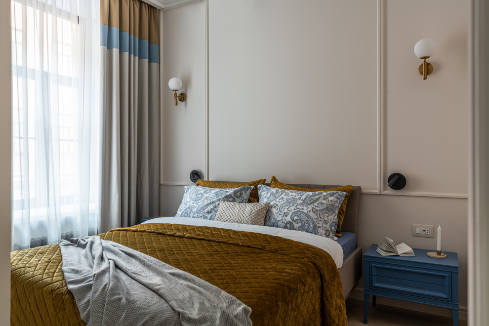Modelo de dormitorio clásico renovado con paredes beige, suelo de madera en tonos medios, suelo marrón y panelado