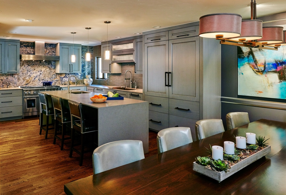 Example of a large trendy l-shaped medium tone wood floor and brown floor eat-in kitchen design in Denver with an integrated sink, shaker cabinets, gray cabinets, quartz countertops, multicolored backsplash, glass tile backsplash, paneled appliances, an island and white countertops