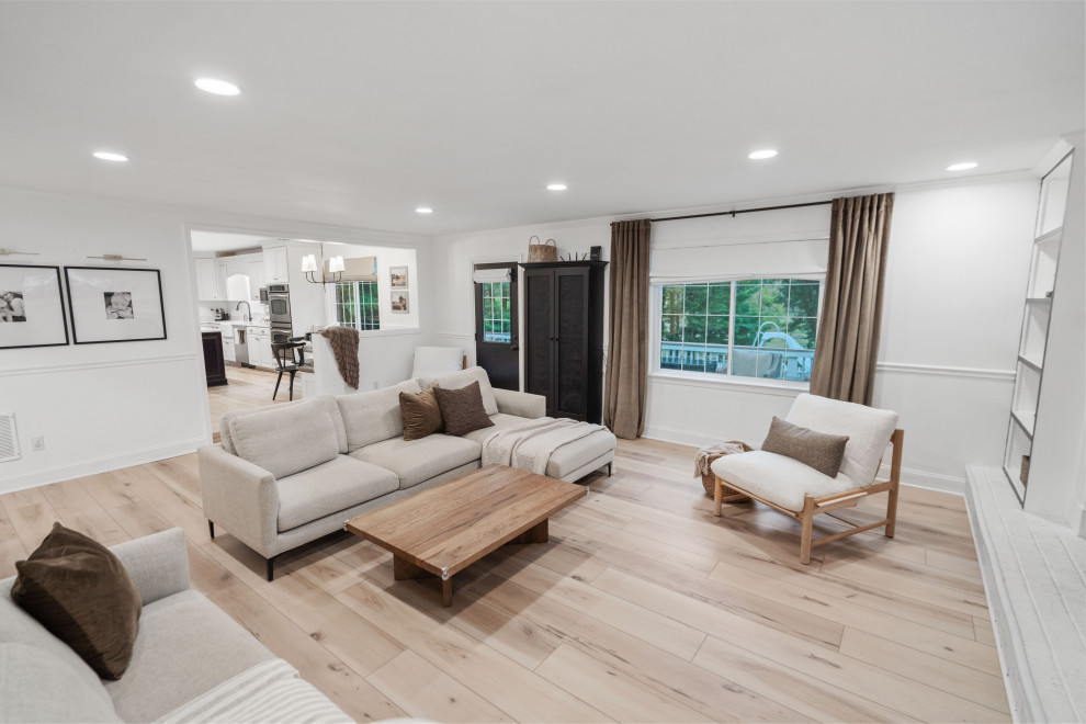 Mid-sized transitional formal open concept living room in DC Metro with white walls, vinyl floors, a wood stove, a brick fireplace surround, a wall-mounted tv, beige floor and vaulted.