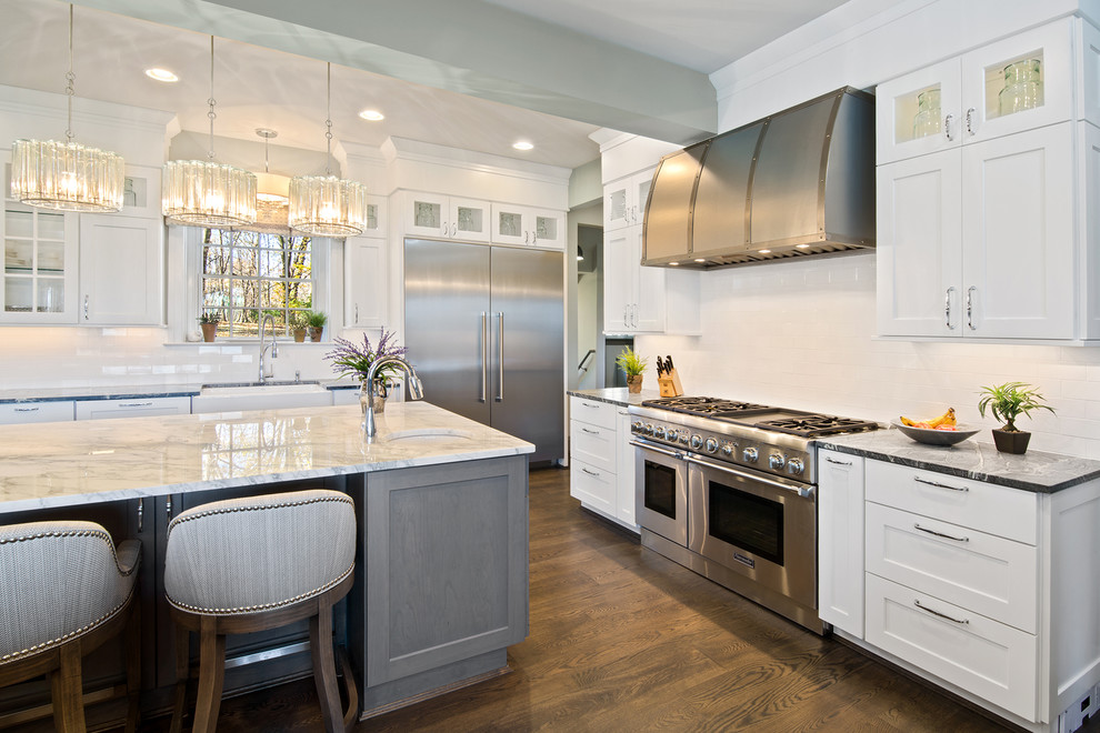 Inspiration for a mid-sized transitional l-shaped eat-in kitchen in Cincinnati with shaker cabinets, white cabinets, soapstone benchtops, white splashback, subway tile splashback, stainless steel appliances and with island.