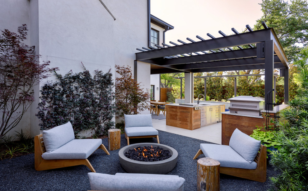 Design ideas for a mid-sized contemporary backyard patio in Dallas with a fire feature and a roof extension.