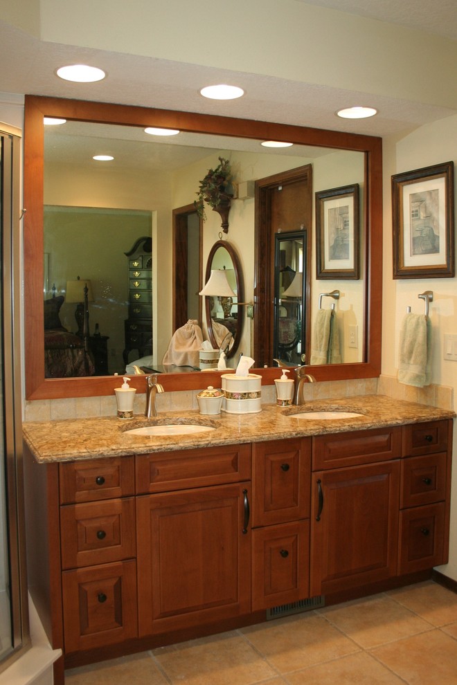 Design ideas for a mid-sized traditional master bathroom in Albuquerque with raised-panel cabinets, medium wood cabinets, marble, an undermount sink, engineered quartz benchtops, a hinged shower door, a corner shower, beige tile, white walls, ceramic floors and beige floor.