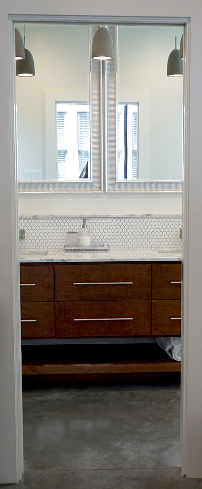 Inspiration for a mid-sized modern master wet room bathroom in Houston with furniture-like cabinets, an alcove tub, white tile, ceramic tile, concrete floors, a drop-in sink, marble benchtops, grey floor, a hinged shower door, white walls and medium wood cabinets.