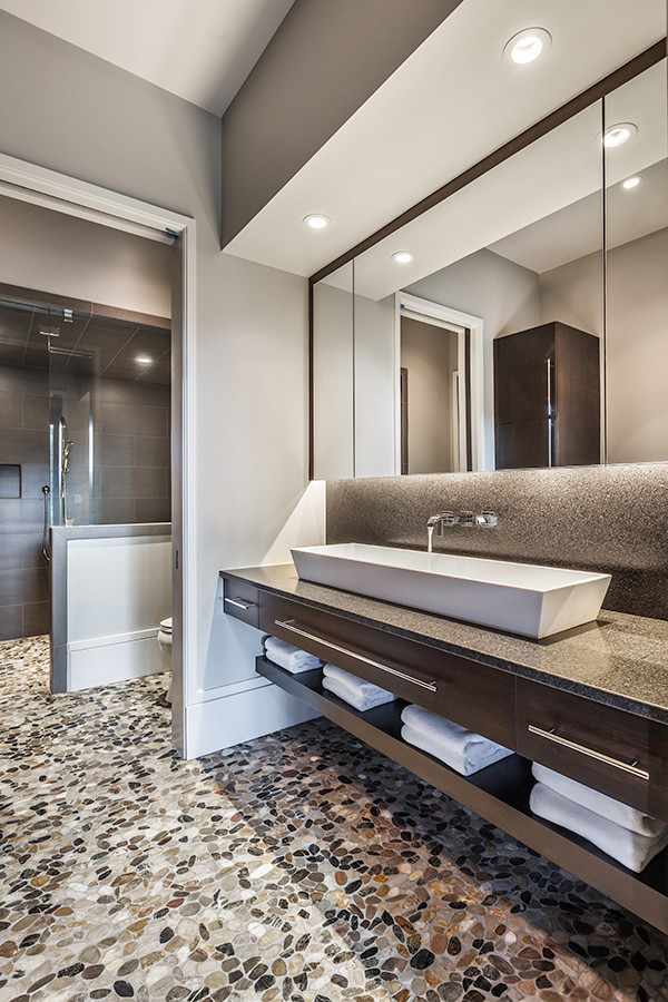 This is an example of a large transitional bathroom in Other with flat-panel cabinets, dark wood cabinets, gray tile, porcelain tile, grey walls, pebble tile floors, a vessel sink, granite benchtops, with a sauna, an open shower, a one-piece toilet, multi-coloured floor and an open shower.