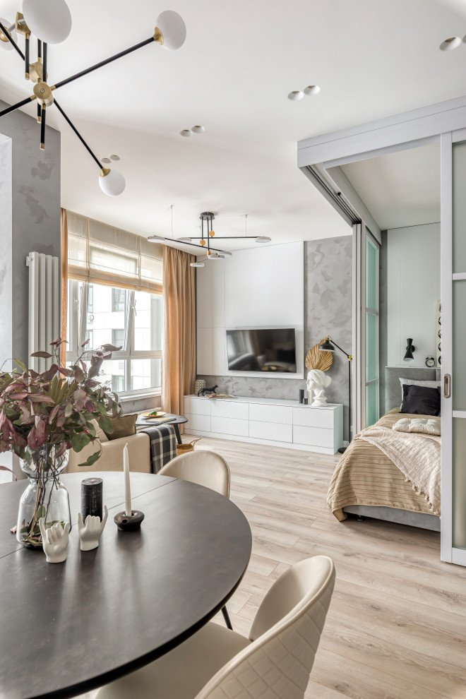 Свежая идея для дизайна: большая серо-белая гостиная комната в скандинавском стиле с серыми стенами, светлым паркетным полом, телевизором на стене и зоной отдыха - отличное фото интерьера