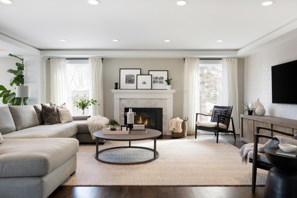 Photo of a mid-sized transitional open concept living room in Minneapolis with beige walls, dark hardwood floors, a standard fireplace, a stone fireplace surround, a wall-mounted tv and brown floor.