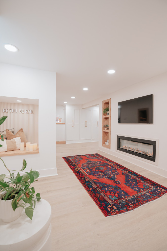Modern fully buried basement in Detroit with a home bar, multi-coloured walls, vinyl floors, a two-sided fireplace, a wood fireplace surround, brown floor and brick walls.
