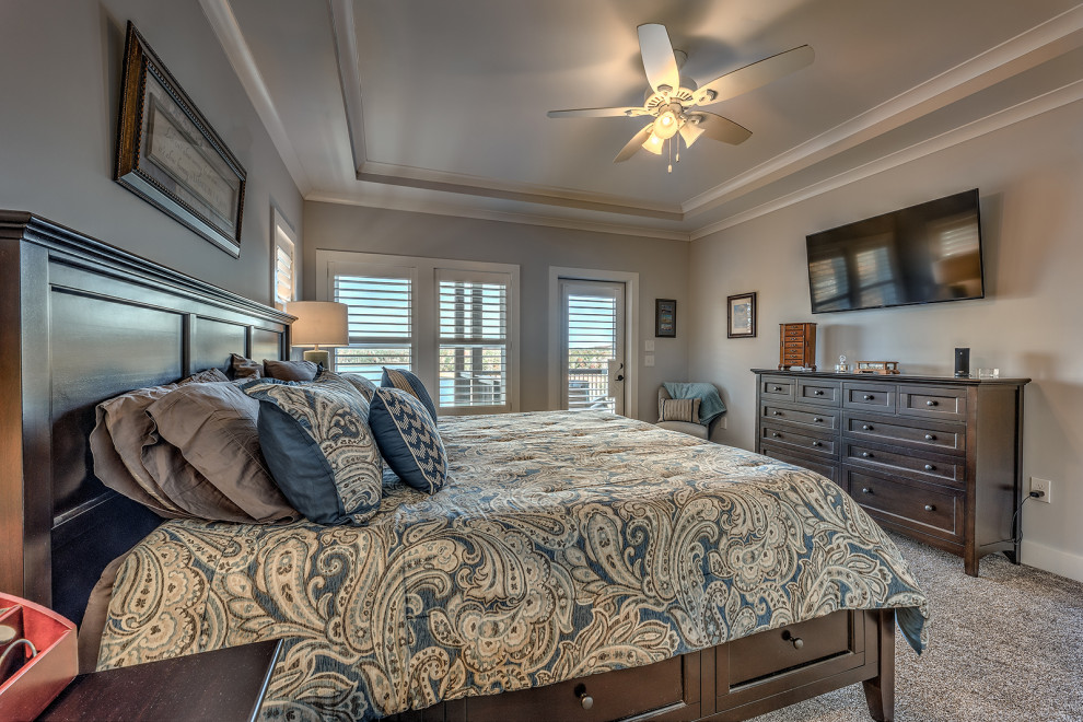 На фото: большая хозяйская спальня в стиле кантри с бежевыми стенами, ковровым покрытием, коричневым полом и многоуровневым потолком с