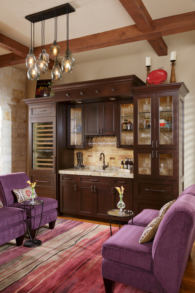 This is an example of a mediterranean single-wall wet bar in Houston with an undermount sink, recessed-panel cabinets, dark wood cabinets and beige splashback.