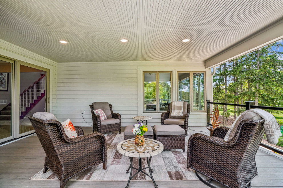 Example of a mid-sized transitional backyard second story cable railing deck design in Columbus with a roof extension