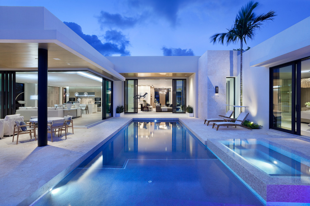 Photo of a mid-sized contemporary backyard rectangular lap pool in Miami with a hot tub and concrete slab.