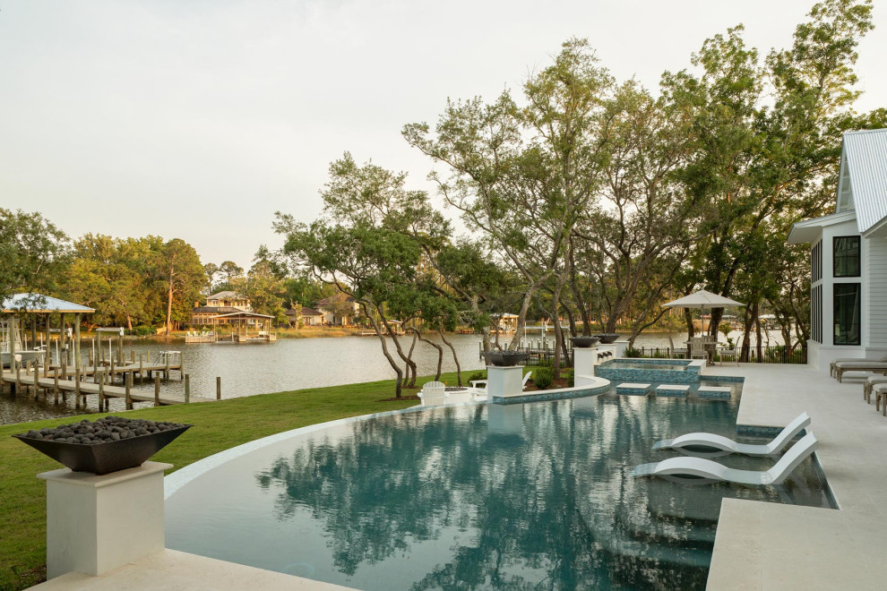 Large transitional backyard concrete paver and custom-shaped infinity hot tub photo