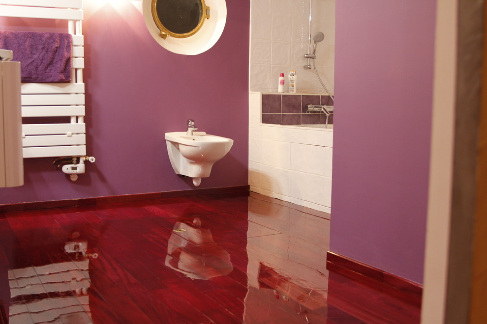 Cette image montre une salle de bain principale minimaliste de taille moyenne avec un combiné douche/baignoire, un carrelage blanc, un mur violet, parquet peint et un bidet.