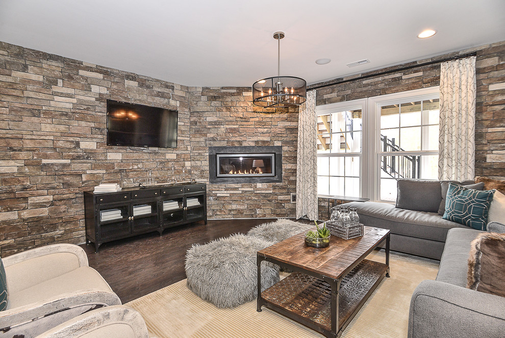 Photo of a mid-sized transitional walk-out basement in DC Metro with grey walls, dark hardwood floors, a ribbon fireplace and a stone fireplace surround.