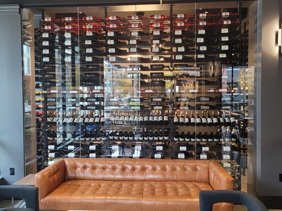 This is an example of a large contemporary wine cellar in Seattle with concrete floors, storage racks and beige floor.