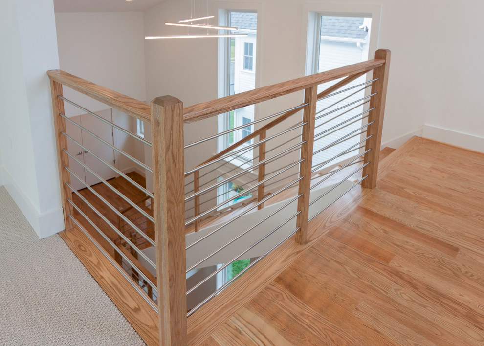 Photo of a large contemporary wood floating staircase in DC Metro with mixed railing.