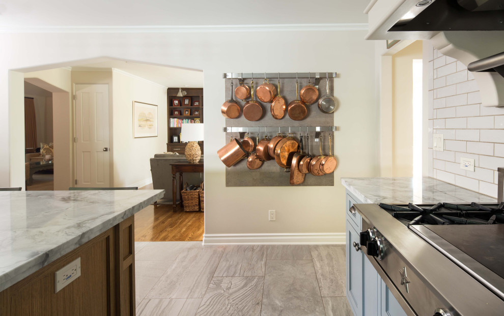 Enclosed kitchen - large transitional u-shaped porcelain tile and gray floor enclosed kitchen idea in Los Angeles with a drop-in sink, shaker cabinets, quartzite countertops, white backsplash, ceramic backsplash, stainless steel appliances, an island and gray countertops