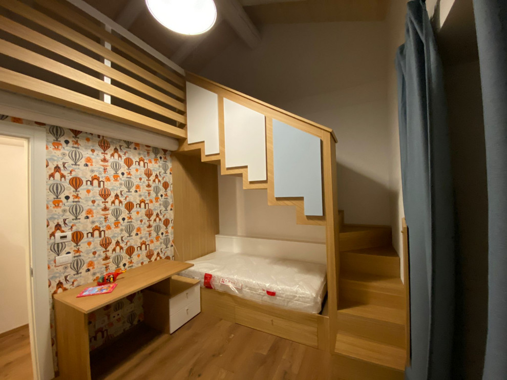 Foto di una cameretta per bambini da 4 a 10 anni scandinava di medie dimensioni con pavimento in laminato e carta da parati