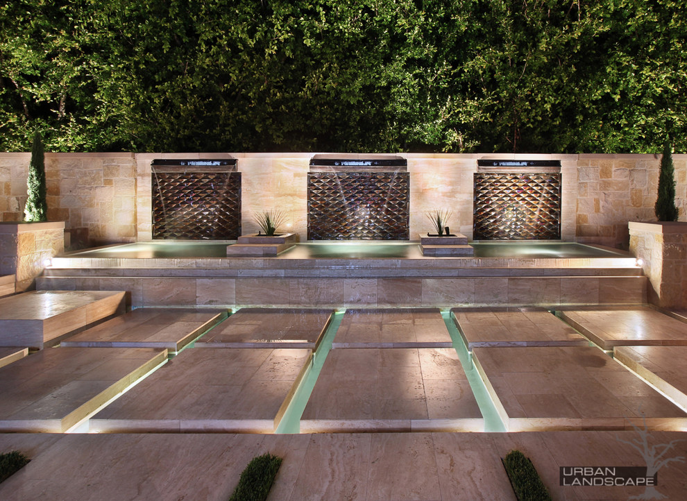 Inspiration for a large contemporary backyard patio in Orange County with a water feature, tile and no cover.