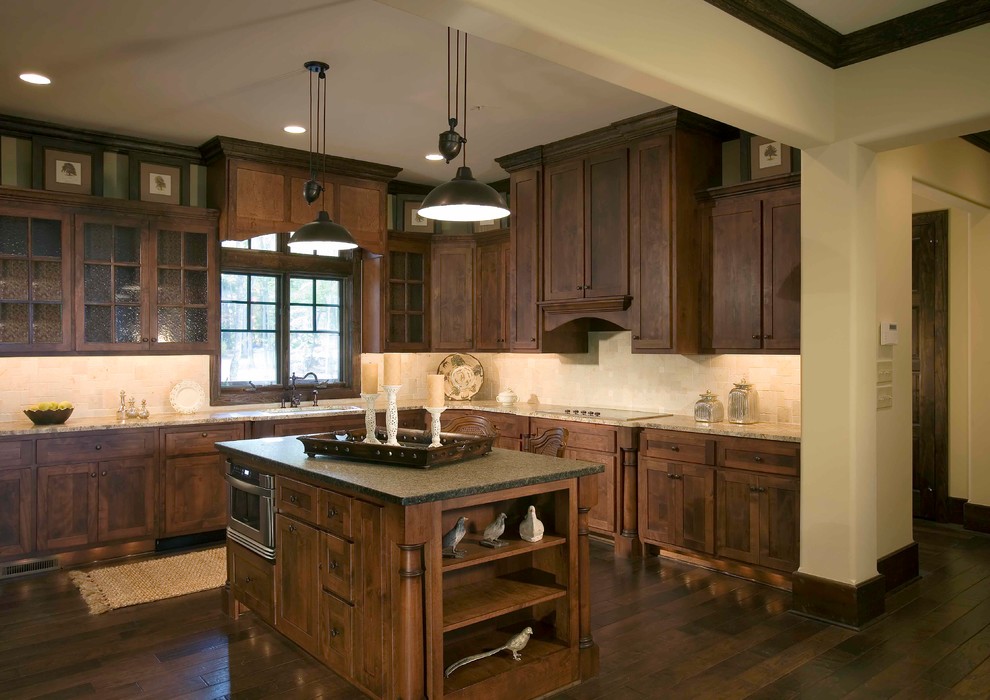 Mountain style dark wood floor kitchen photo with a drop-in sink, beige backsplash, glass tile backsplash and stainless steel appliances