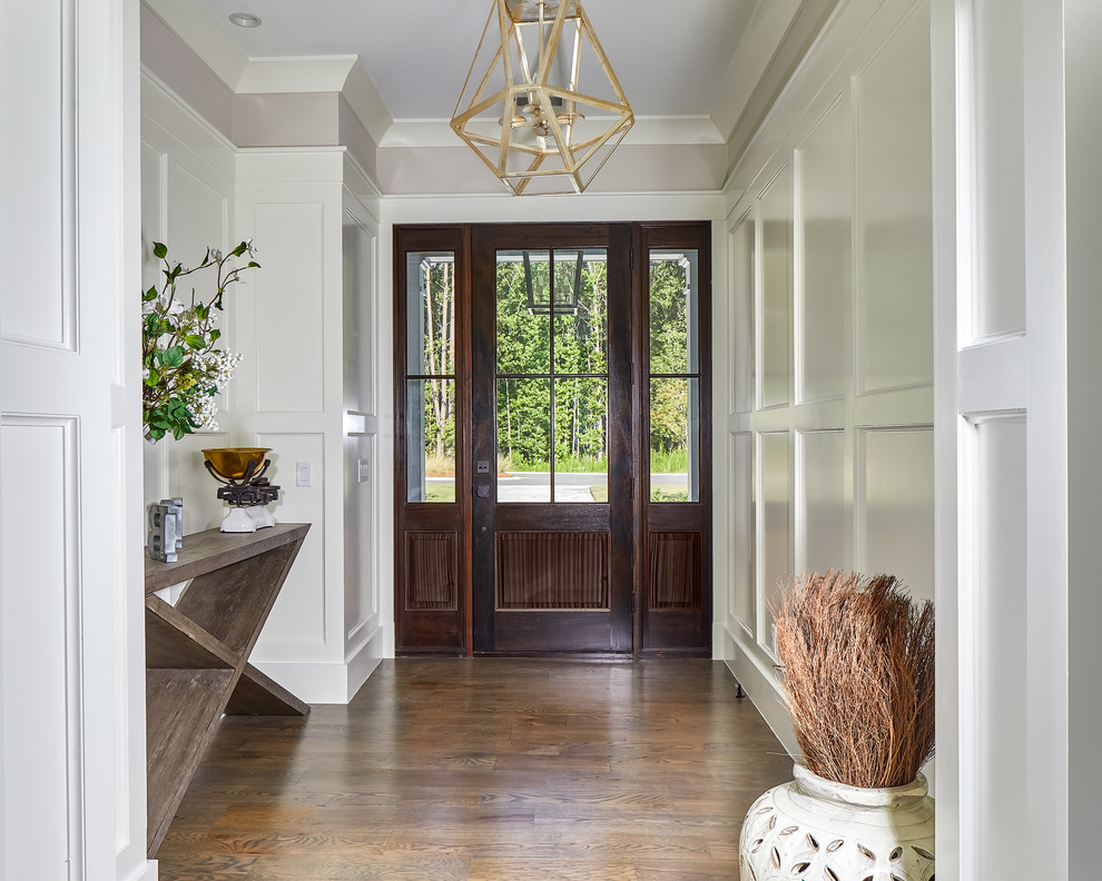 This is an example of a mid-sized beach style foyer in Charleston with grey walls, medium hardwood floors, a single front door, a dark wood front door and brown floor.