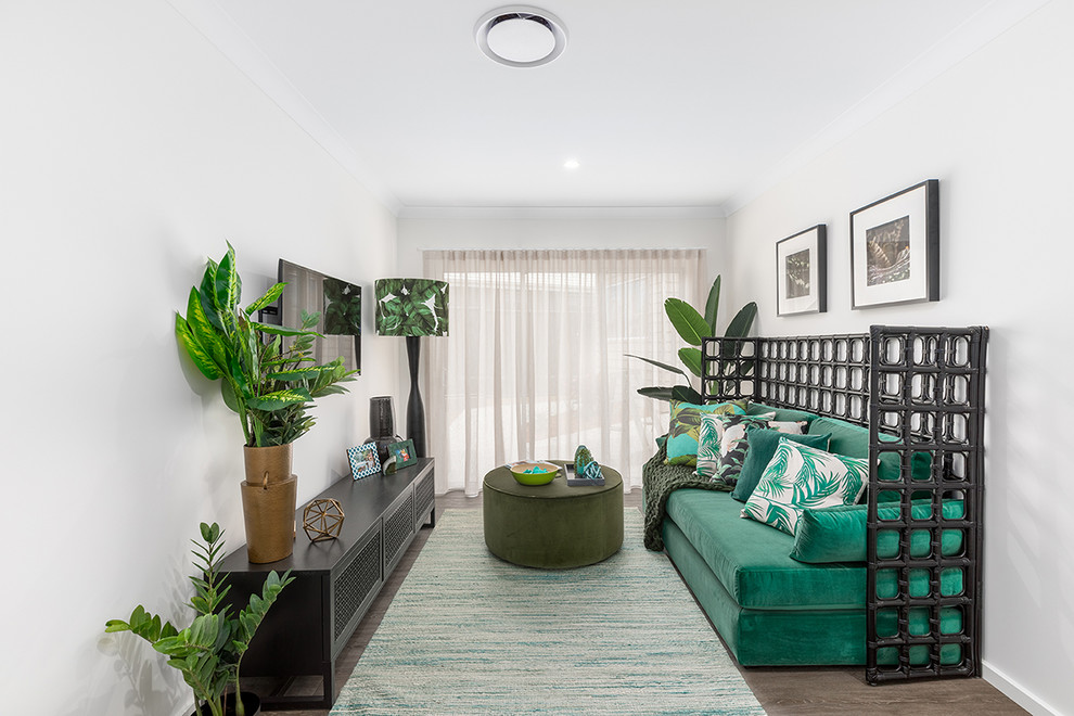 Tropical family room in Brisbane with white walls, medium hardwood floors, a wall-mounted tv and brown floor.