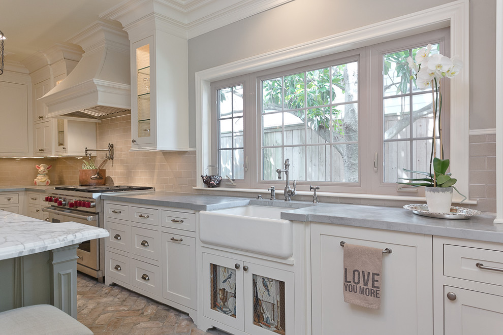 Inspiration for a mid-sized country u-shaped open plan kitchen in Houston with a farmhouse sink, recessed-panel cabinets, white cabinets, zinc benchtops, beige splashback, stainless steel appliances, brick floors and with island.