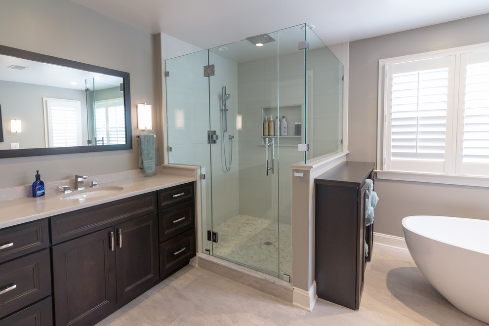 Inspiration for a large contemporary master bathroom in Philadelphia with raised-panel cabinets, dark wood cabinets, a freestanding tub, a corner shower, grey walls, an undermount sink, wood benchtops, beige floor, a hinged shower door and beige benchtops.